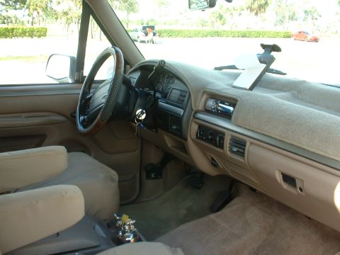 1994 Ford Bronco - The interior of a 1992 Ford Bronco shows a tan dashboard, steering wheel, and seats.