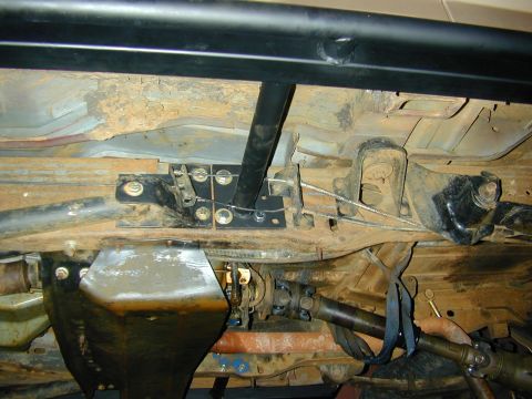 1996 Ford Bronco - Close-up of the undercarriage, showing the drive shaft and suspension system of a vehicle.