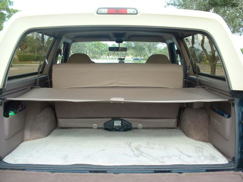1994 Ford Bronco - Rear cargo area of a 1994 Ford Bronco, showing the folded rear seat and cargo cover.