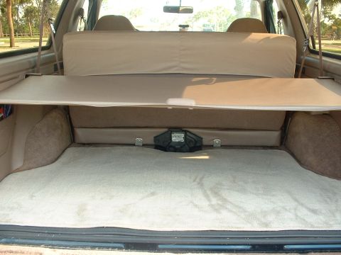 1994 Ford Bronco - The rear cargo area of an SUV is shown, a removable cargo cover and carpeting.