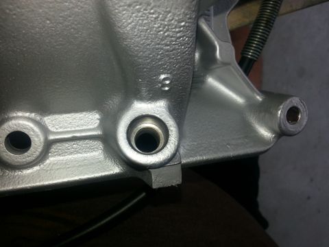 1994 Ford Bronco - Unidentified cast metal engine part with visible bolt holes and threaded openings.