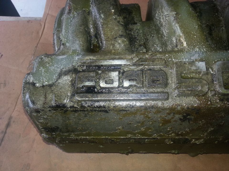 Engine part with embossed text 'FORD'