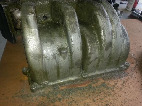 1994 Ford Bronco - Close-up of an intake manifold, likely needing cleaning or repair.