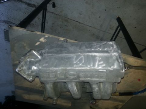 1994 Ford Bronco - An aluminum intake manifold with 'EDELBROCK' cast into its side sits on a wooden surface.