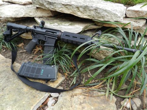 1996 Ford Bronco - AR-15 style rifle with magazine and sling, placed on rocks and grass.