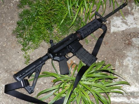 1996 Ford Bronco - AR-15 style rifle with adjustable stock and sling is placed on the ground.