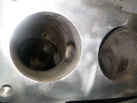 1994 Ford Bronco - Close-up view of an engine cylinder head showing two valves, one open and one closed, with carbon buildup.