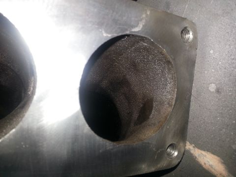 1994 Ford Bronco - This is a close-up view of a metal engine part, likely a manifold or cylinder head, showing its internal openings.
