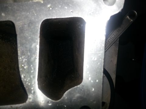 1994 Ford Bronco - A close-up view of an engine's intake manifold, with a wrench partially visible on the right side.