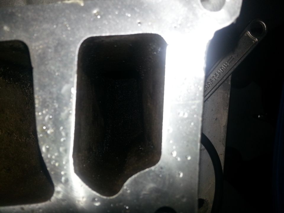 Close-up of an engine intake manifold with a wrench visible