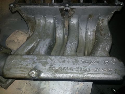 1994 Ford Bronco - Close-up of an engine intake manifold, showing the part number RF-FOTE-9425-BA stamped into the metal.