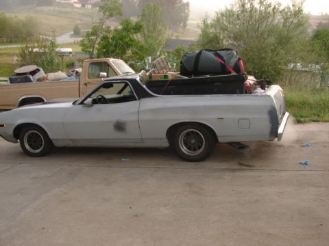 1973 Ford Ranchero - A light gray 1972 Ford Ranchero is parked next to a tan pickup truck, both loaded with items in their beds.