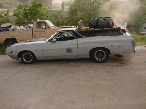 1973 Ford Ranchero - A gray 1972 Ford Ranchero is parked next to a tan pickup truck, with the Ranchero's bed loaded with gear.