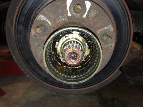 1990 Ford Bronco - Close-up view of a vehicle's wheel hub assembly and brake rotor, showing internal splines and grease.