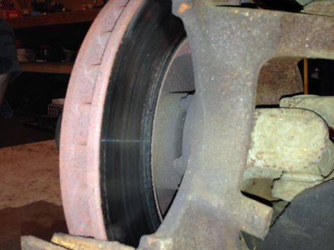 1990 Ford Bronco - This image shows a close-up view of a vehicle's brake rotor and caliper, highlighting wear and rust on the components.