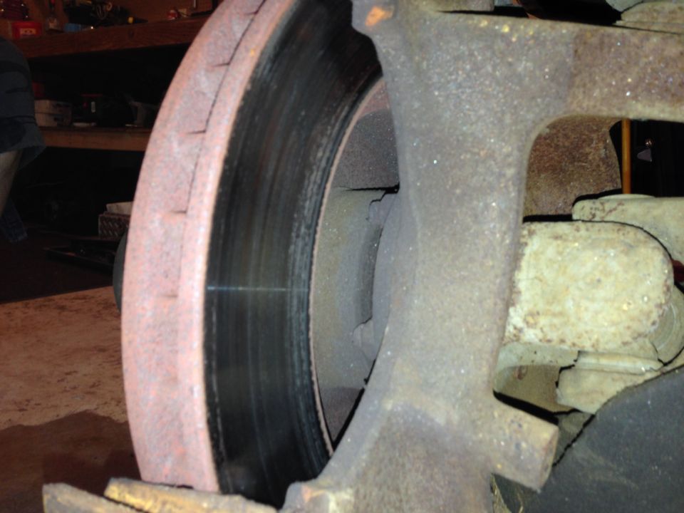 close-up of a rusty brake rotor and caliper assembly
