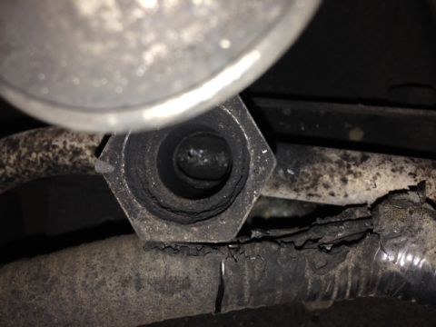 1996 Ford Bronco - Close-up of a worn exhaust pipe fitting and a damaged hose, showing signs of wear and tear.