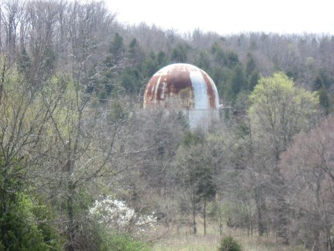 2006 Suzuki DR-Z400S - A large, weathered, domed structure is partially obscured by trees in a rural landscape.