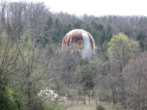 2006 Suzuki DR-Z400S - A large, domed structure with significant rust is seen through a dense forest.