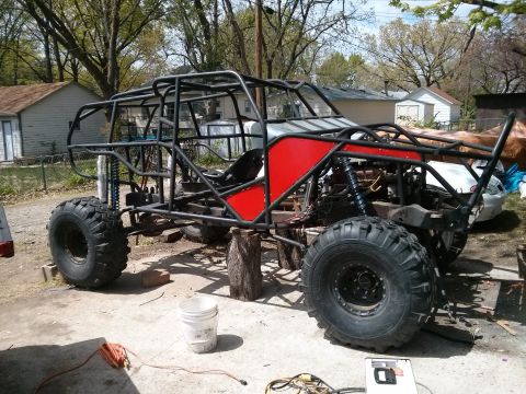 1986 Ford Bronco - This custom-built off-road buggy is in progress, a prominent roll cage and large tires.
