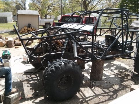 1986 Ford Bronco - This custom buggy frame is undergoing modifications, with a red pickup truck in the background.