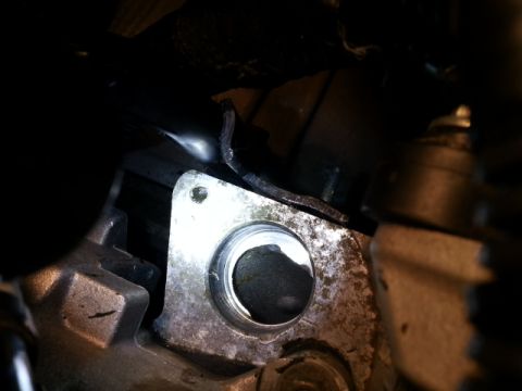 2004 Mercury Grand Marquis - A close-up view of a metal engine part, possibly a housing or adapter, with a dark circular opening.