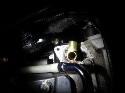 2004 Mercury Grand Marquis - A brass fitting is connected to a part of the engine, with various hoses and wiring visible.