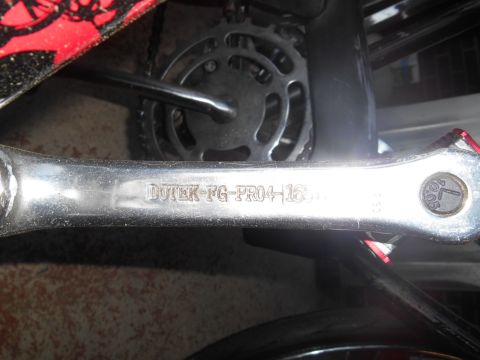 Close-up of a bicycle crank arm with 'DOTEX-FG-PRO4-15' stamped on it