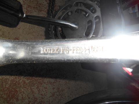 Bicycle crank arm with 'DOTEK-FG-PRO' and '165mm' stamped on it