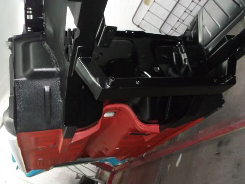 1967 Ford Mustang - Undercarriage view of a car frame, showing painted floor pans and structural supports.