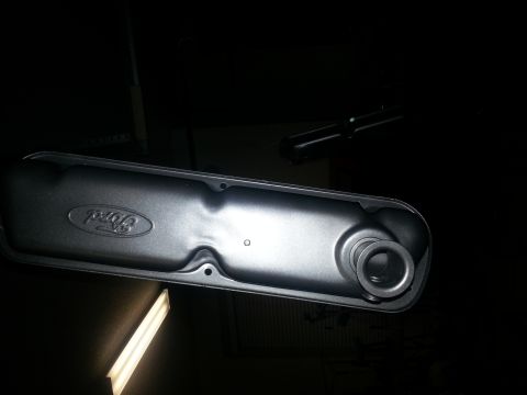 1994 Ford Bronco - A black Ford valve cover is shown, with the Ford logo embossed on its surface.