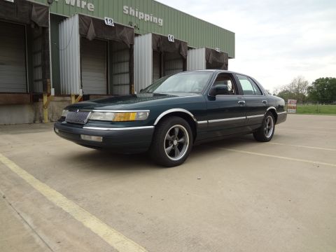 1993 Mercury Grand Marquis - This 1993 Mercury Grand Marquis is seen parked in front of a warehouse with its distinctive grille and body style.