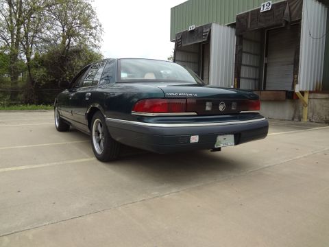 1993 Mercury Grand Marquis - Rear view of a 1993 Mercury Grand Marquis LS parked in a lot near industrial loading docks.