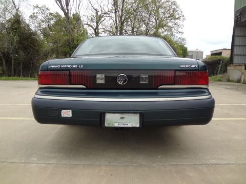 1993 Mercury Grand Marquis - The rear of a dark green Mercury Grand Marquis LS is shown, its distinctive taillights and badging.