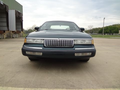 1993 Mercury Grand Marquis - Front view of a dark green sedan with a chrome grille and black bumper.