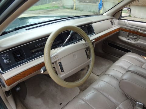 1993 Mercury Grand Marquis - The interior of a 1993 Mercury Grand Marquis shows tan leather seats and wood trim accents.