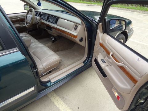 1993 Mercury Grand Marquis - The interior of a 1993 Mercury Grand Marquis shows tan leather seats and wood grain accents on the dashboard and door panels.