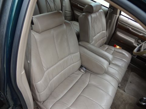 1993 Mercury Grand Marquis - The interior of a car features plush tan leather seats and a wood-trimmed door panel.