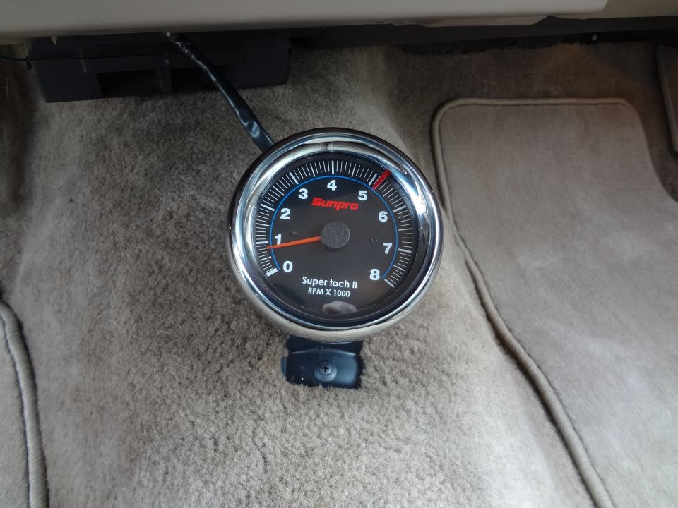 Sunpro Super tach II RPM x 1000 gauge mounted on tan carpet