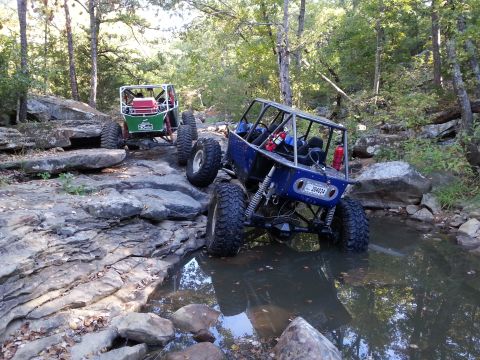 1967 Ford Mustang - Custom off-road buggies tackle a challenging rocky stream on a trail.