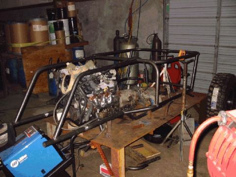 1994 Ford Bronco - Custom tube chassis project in a workshop, an engine and transmission assembly.