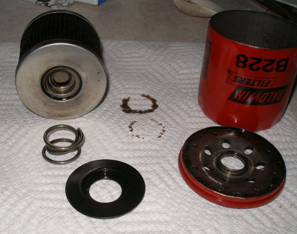 Baldwin B228 oil filter disassembled with springs and gasket on a paper towel