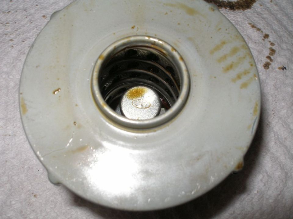 Close-up of an oil filter with a metal center piece and visible spring