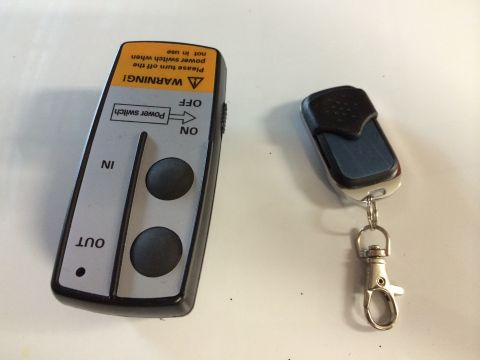 1996 Ford Bronco - Winch remote control and a car key fob are shown side-by-side on a white surface.