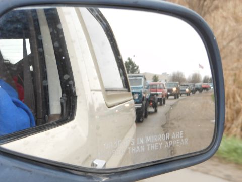 1995 Ford Bronco - Reflection shows a line of SUVs driving on a road, seen in a side mirror.