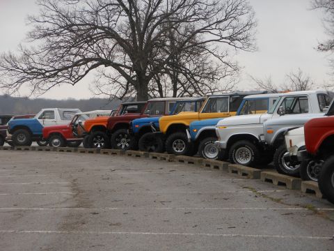 1995 Ford Bronco - A collection of classic Ford Broncos are lined up, their distinct body styles and colors.