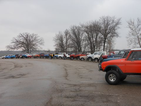 1995 Ford Bronco - A group of Ford Broncos gathered together on a gray day, with an orange Bronco prominently in the foreground.
