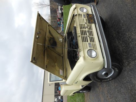 1995 Ford Bronco - This SUV, likely from the early 1970s, has its hood open, revealing the engine bay. The license plate reads TAT 750.