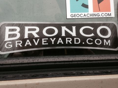 1995 Ford Bronco - A sticker reading 'BRONCO GRAVEYARD.COM' is affixed to the glass of a vehicle.