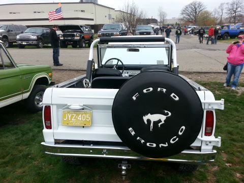1995 Ford Bronco - A white Ford Bronco is parked on grass, with other vehicles and people in the background.